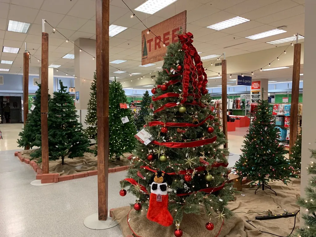 Pre-lit artificial Christmas trees on display in a department store