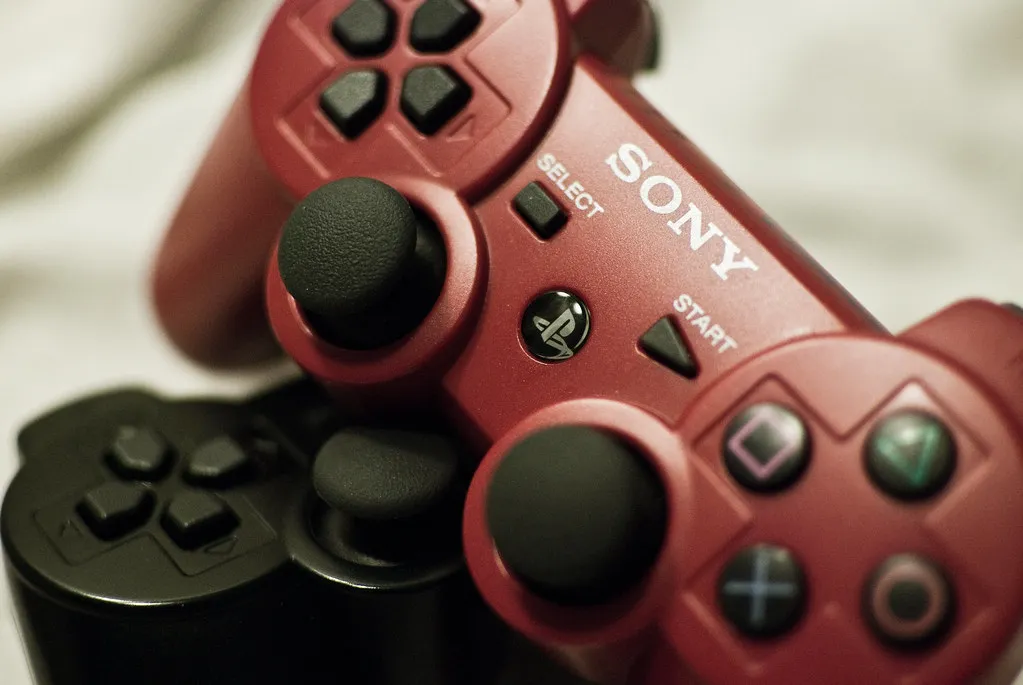 Red and black PlayStation DualShock 3 controllers