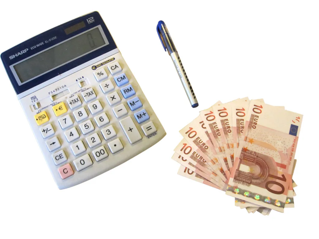Calculator, pen and cash on a white desk